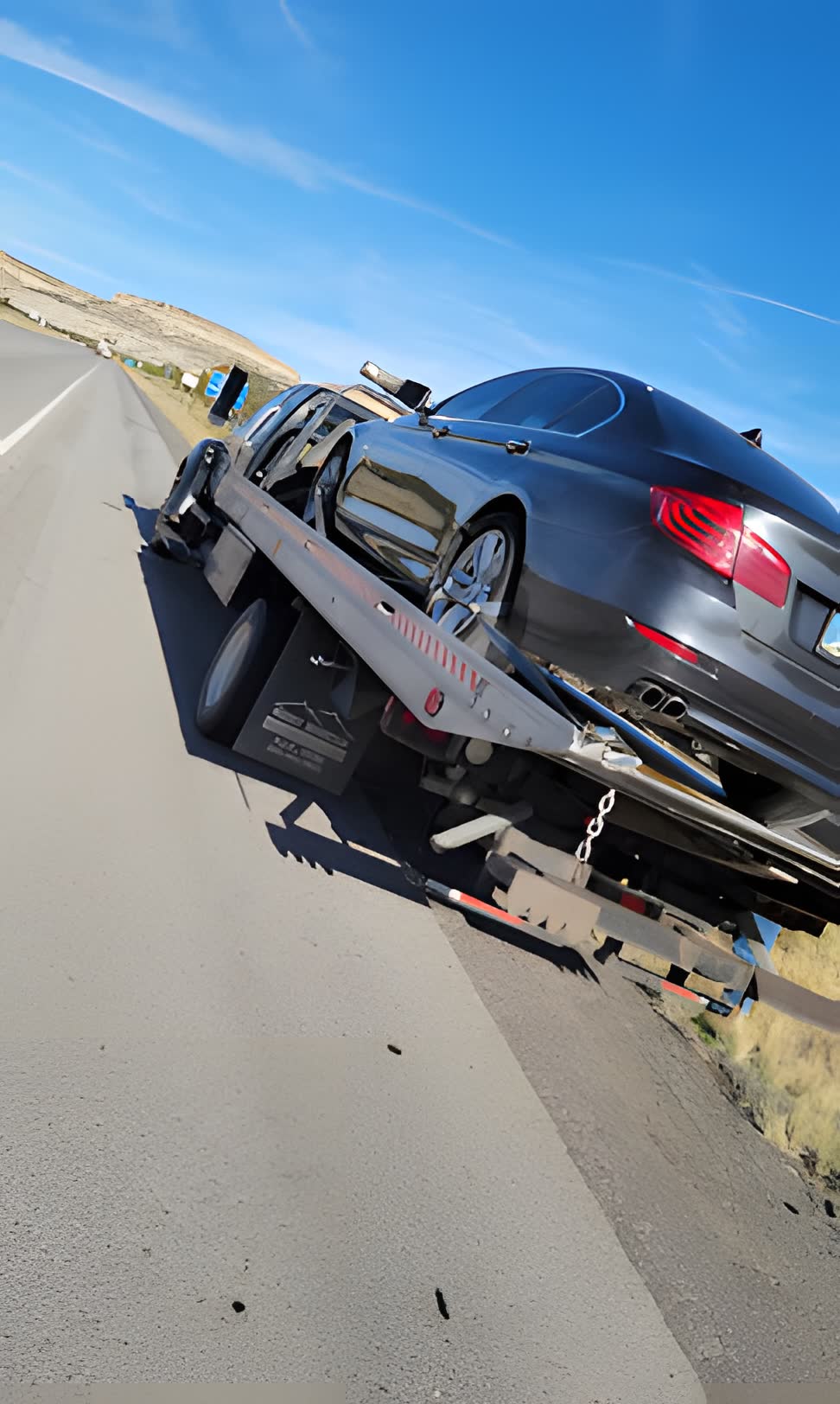 Flatbed tow with sedan loaded
